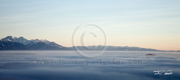Mission Mountains rise above fog filling the Flathead basin