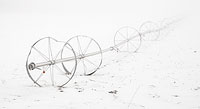An old wheel-line irrigator disappears into the fog